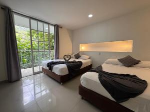 a bedroom with two beds and a large window at Montes De Beraka in Minca +57 photos