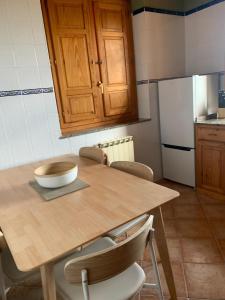 a kitchen with a wooden table with chairs and a refrigerator at Escuelas de collía A AT-1537-AS in Arriondas