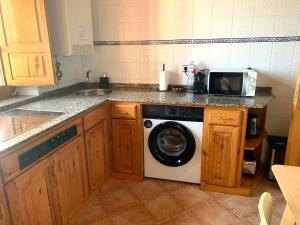 a kitchen with a washing machine and a microwave at Escuelas de collía A AT-1537-AS in Arriondas +18 photos