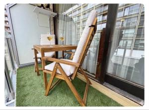 a wooden chair with a table and glasses of wine at Studio Palace 217 in Middelkerke