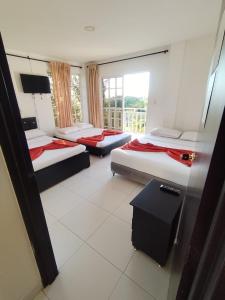 a hotel room with three beds and a window at Finca el Amanecer - 30P - Pool in Quimbaya +30 photos