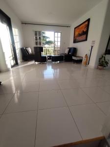 a living room with chairs and a large white tile floor at Finca el Amanecer - 30P - Pool in Quimbaya