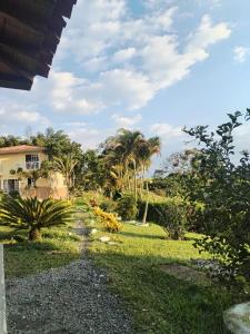 a garden with palm trees and a house at Finca el Amanecer - 30P - Pool in Quimbaya