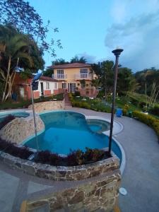 a pool in a yard with a house in the background at Finca el Amanecer - 30P - Pool in Quimbaya