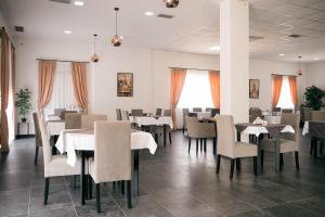 a dining room with tables and chairs and windows at Capital Rooms in Ulcinj