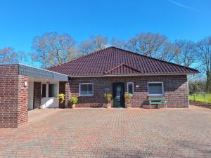 a brick house with a brick driveway in front of it at Huus 8 in Westoverledingen
