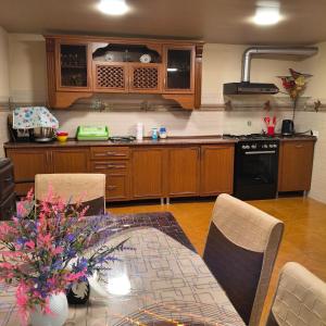 a kitchen with a table and chairs and a kitchen with a stove at Guesthouse - Happy house in Kutaisi in Kutaisi