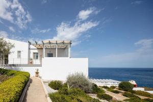 a white house with the ocean in the background at Tersanas Seaside Apartment in Tersanas