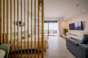 a bedroom with a bed and a couch at Apartamentos Sibarys in Nerja