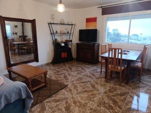 a living room with a table and a mirror at La Casuca in El Pelayo