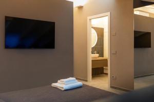 a bathroom with a television and a pile of towels at Villa Eliseo Luxury Suites in Modena