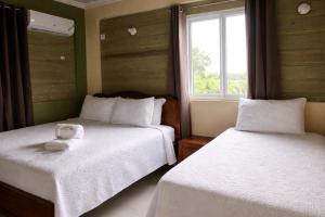 a bedroom with two beds and a window at Incognito Reggae Rooms in Kingston +38 photos