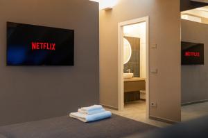 a bathroom with a tv on the wall and towels at Villa Eliseo Luxury Suites in Modena +6 photos