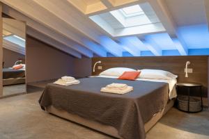 a bedroom with a large bed with towels on it at Villa Eliseo Luxury Suites in Modena