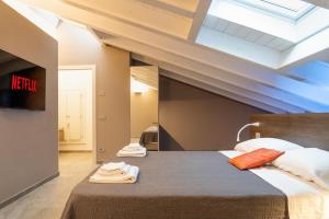 a bedroom with a large bed with towels on it at Villa Eliseo Luxury Suites in Modena