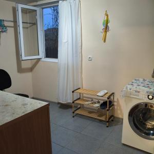 a laundry room with a washing machine and a window at Guesthouse - Happy house in Kutaisi in Kutaisi