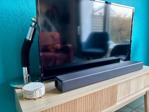 a television sitting on a table with a hair dryer at House & garden l'Hippodrome in Bredene +20 photos