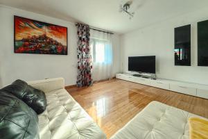 a living room with a couch and a flat screen tv at Paradise Garden Villa in Bečići
