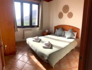 a bedroom with a bed with towels on it at Escuelas de collía C AT-1537-AS in Arriondas