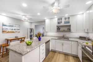 a kitchen with white cabinets and a ceiling fan at San Marco Villas H-3 in Marco Island