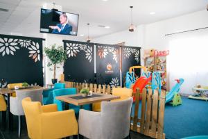 a restaurant with tables and chairs and a tv on the wall at Capital Rooms in Ulcinj