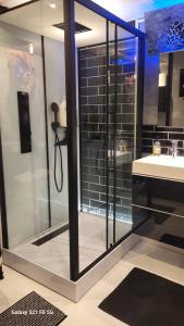 a bathroom with a glass shower with a sink at Dans un parc privatif arboré in Réau +25 photos