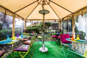 a tent with tables and chairs in a garden at Riad Rooms in Sarnico
