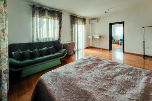 a living room with a green couch and a bed at Paradise Garden Villa in Bečići