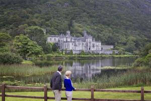 a man and woman standing on a fence in front of a castle at Property 472 - Kylemore in Kylemore