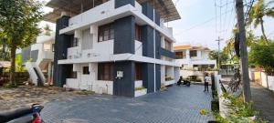 a blue and white building on a street at RITU CAPITOL Homestay in Trivandrum
