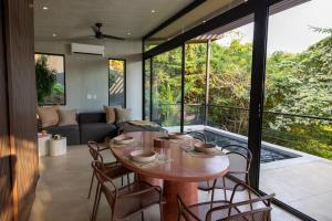 a living room with a wooden table and chairs at Garden Treehouse Ikhaya in Refundores