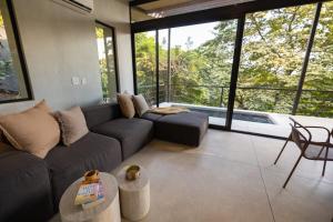 a living room with a couch and a table at Garden Treehouse Ikhaya in Refundores