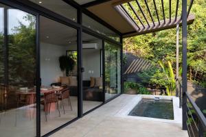 a glass extension of a house with a swimming pool at Garden Treehouse Ikhaya in Refundores