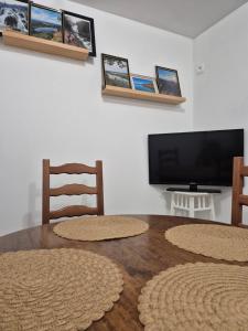 a living room with two chairs and a flat screen tv at Studio Les Sapins in Chapois