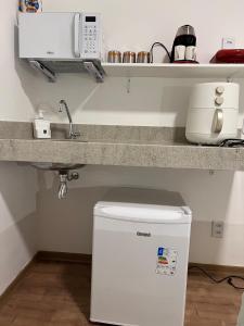 a kitchen with a counter with a sink and a refrigerator at Aconchego Corrêas in Petrópolis