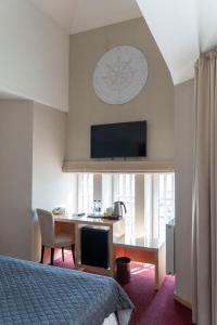 ein Hotelzimmer mit Schreibtisch und Bett in der Unterkunft Hotel Kolumbs in Liepāja