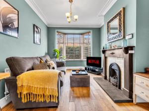 a living room with a couch and a fireplace at Spacious Stoke Townhouse 3BR Near Hospital & M6 with Parking in Stoke on Trent