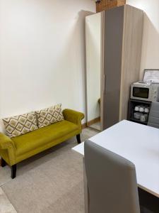 a living room with a yellow couch in a room at Falconwood in Ifton Heath