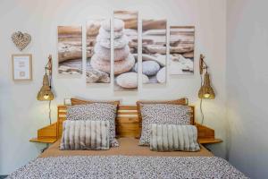a bedroom with a bed with four pictures on the wall at L'Escale Sud Gironde - Séjour en amoureux avec jacuzzi privatif - Piscine - Massage Traiteur & Brunch possibles in Pompéjac +29 photos