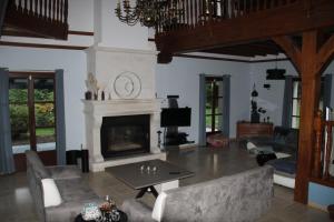 a living room with a fireplace and couches at Chambres d'hôtes les Boulommiers in Samois-sur-Seine