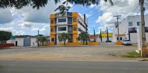 a yellow and white building in a parking lot at Esplendor Palace Hotel in Vitória da Conquista