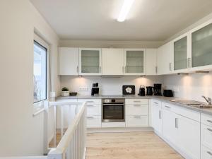 a white kitchen with white cabinets and a sink at Cozy Home in Timmendorfer Strand +39 photos