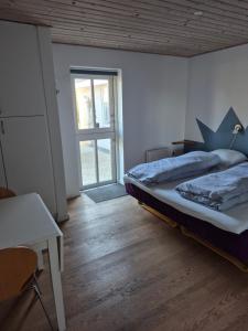 a bedroom with a large bed and a window at Marias house i Agger in Vestervig