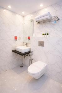 a white bathroom with a toilet and a sink at Hotel Golden Oasis - 5 Minute Walk from New Delhi Railway Station in New Delhi +26 photos
