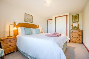 a bedroom with a large white bed and a dresser at 1 Bed in Padstow oc-p00554 in Saint Merryn