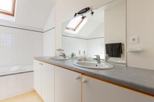 a bathroom with two sinks and a mirror at Villa Yantet - Conciergerieland in Soustons