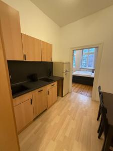 a kitchen with wooden cabinets and a large window at Fürstenhof Belle Etage Altstadt- Parkplatz im Innenhof in Wismar +17 photos