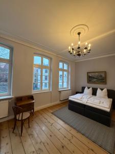 a bedroom with a bed and a table and windows at Fürstenhof Belle Etage Altstadt- Parkplatz im Innenhof in Wismar