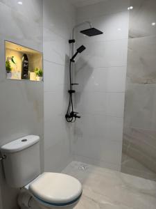 a white bathroom with a toilet and a shower at Apartamento con wifi in Nador