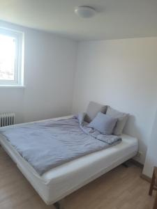 a bed in a room with a white wall at Yellow house in Skene